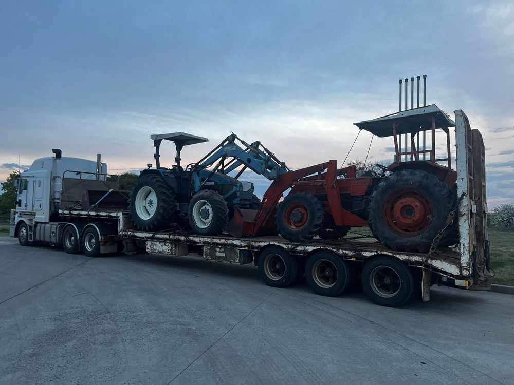 Broken Down Tractors in A Tow Truck