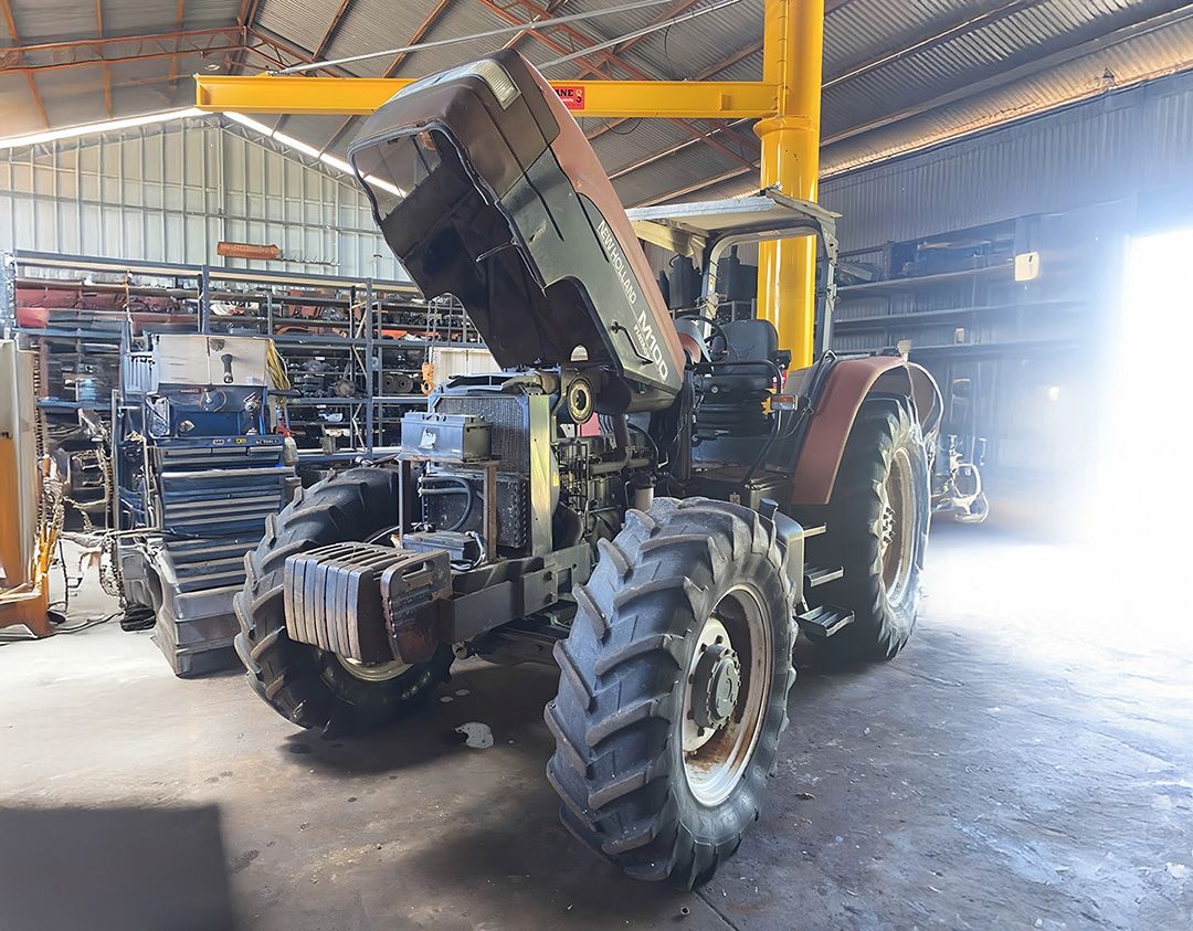 Tractor Hood Open For Engine Parts Inspection In Workshop